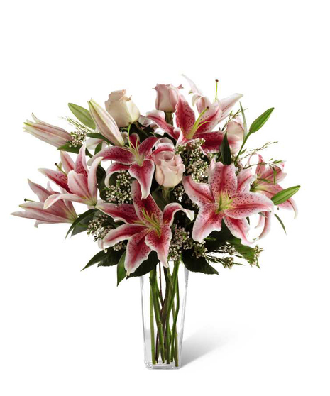 Pink roses, stargazer lilies and greens in a glass vase.